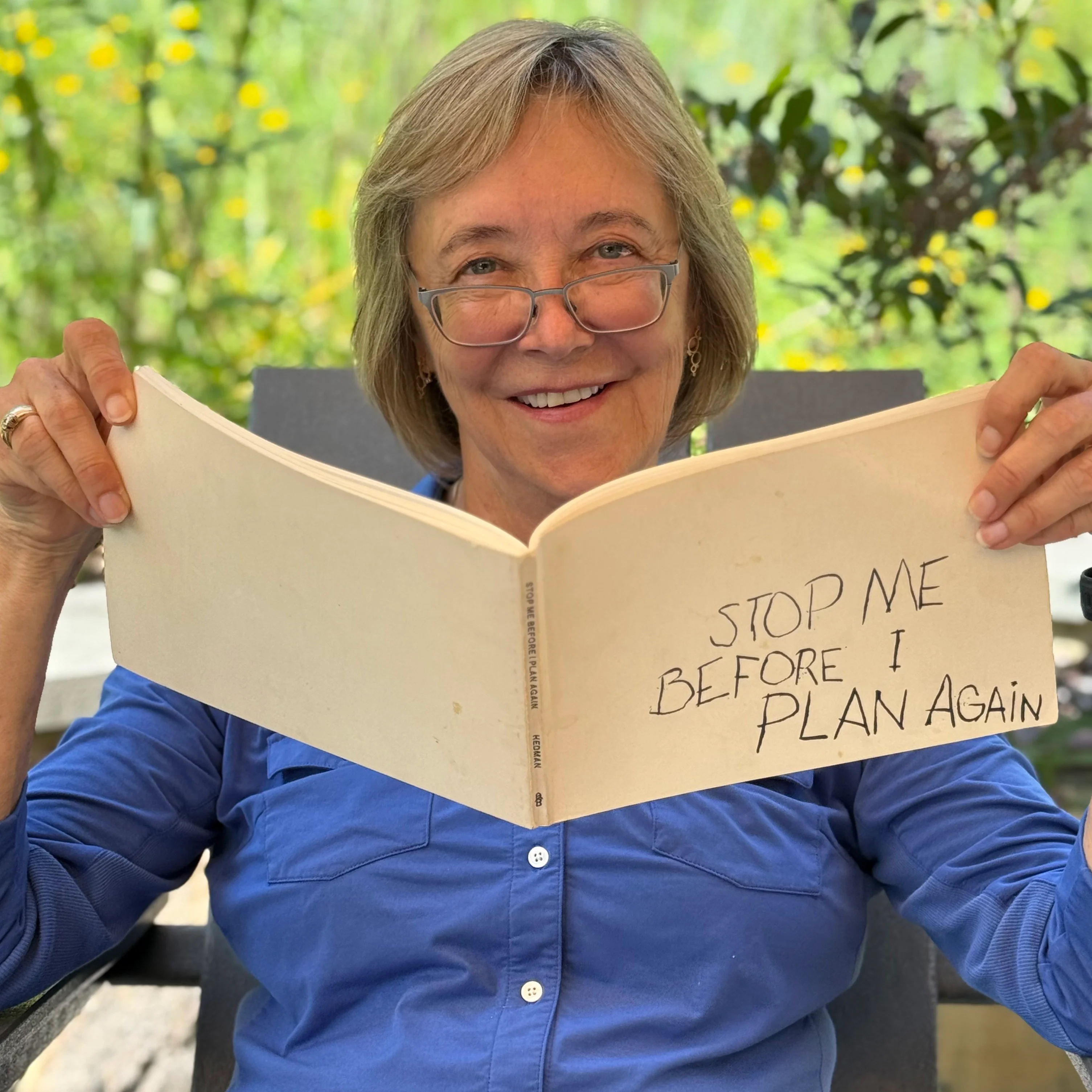 Portrait of Kat Imhoff, seated and holding a book.